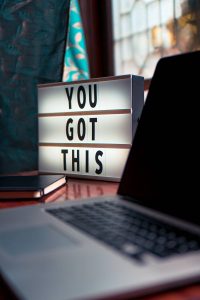 Lightbox on desk next to laptop displaying 'You got this'